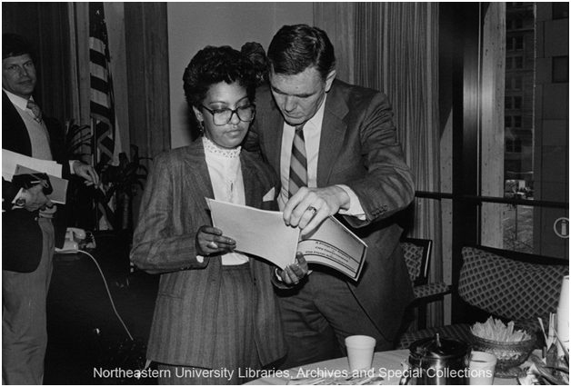 Carmen Pola and Mayor Ray Flynn view a report in the Mayor's office, ca. 1986