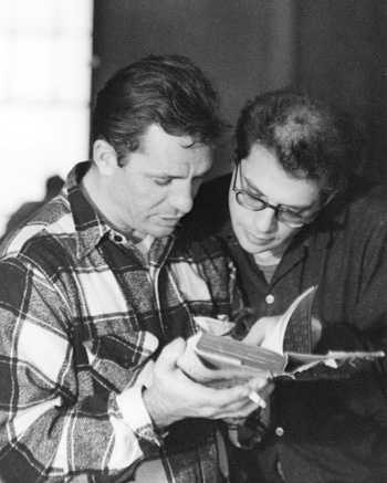 A black and white photo of Jack Kerouac and Allen Ginsberg looking at a book