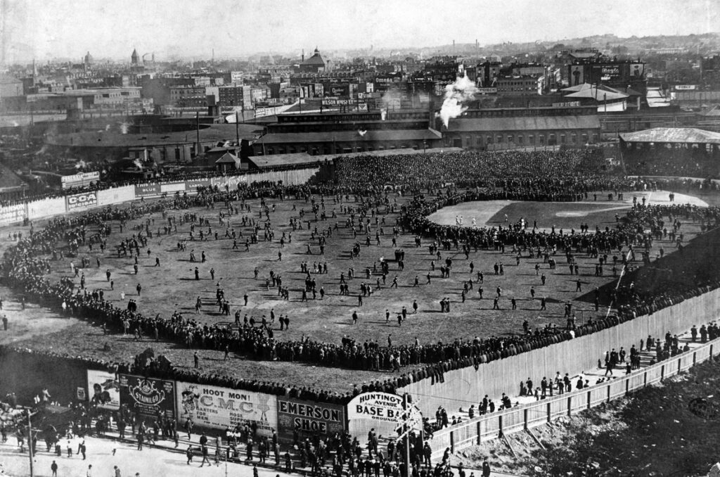 Black and white image of people crowding the field of the Huntington Avenue Baseball Grounds