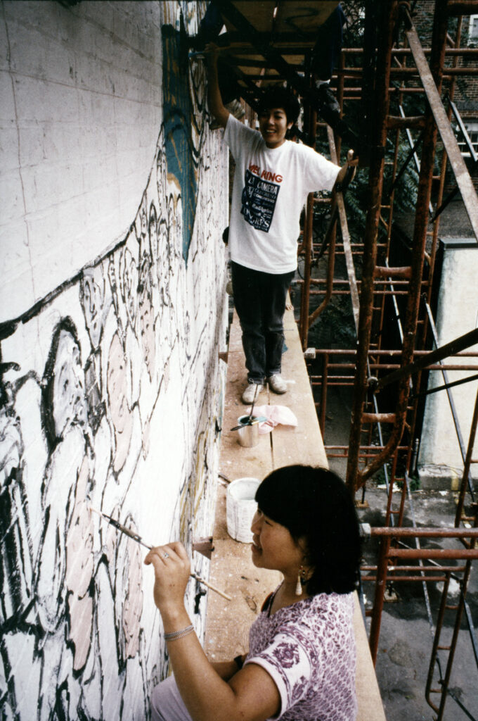 Two women painting a mural