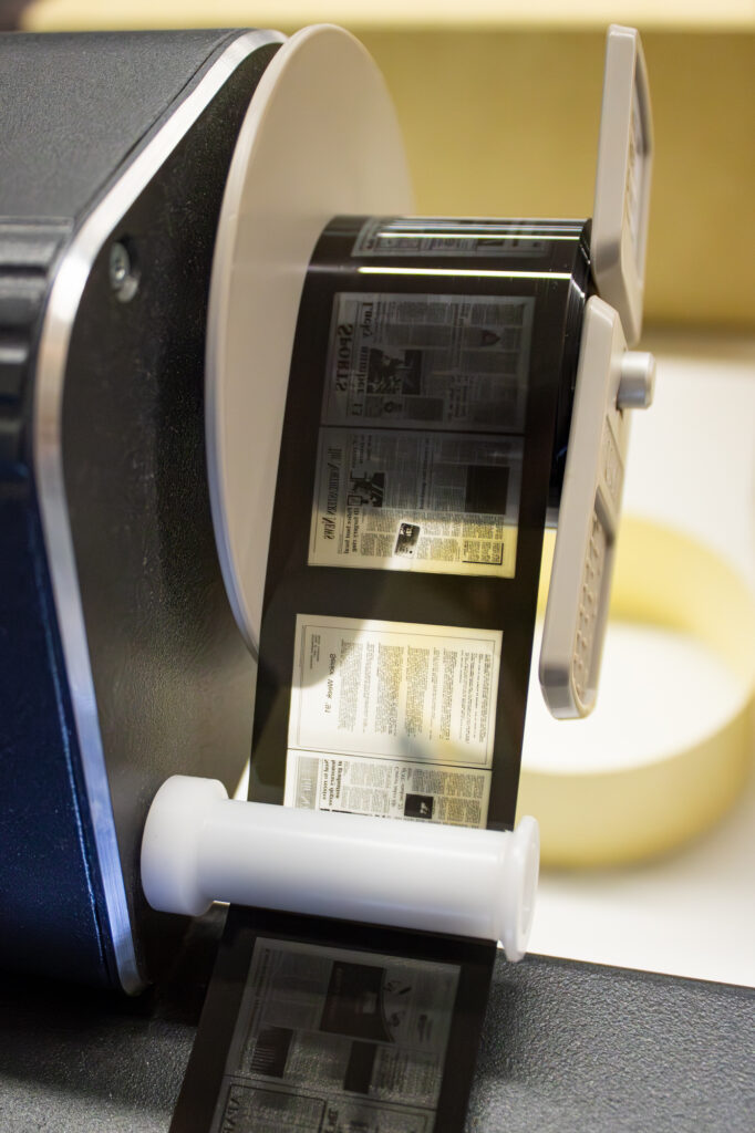 A close-up of a reel of microform running through a reader